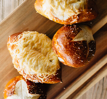 Freshly baked pretzel bites on wooden cutting board