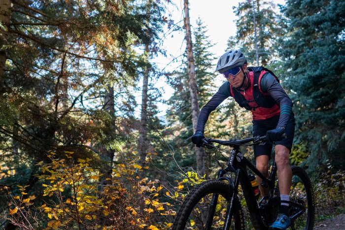 A man mountain biking through the wild rose trail in Davis County, Utah.